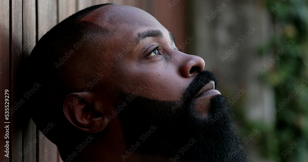 Thoughtful black man with eyes closed. Pensive African guy opening eyes Thoughtful black man with eyes closed. Pensive African guy opening eyes
