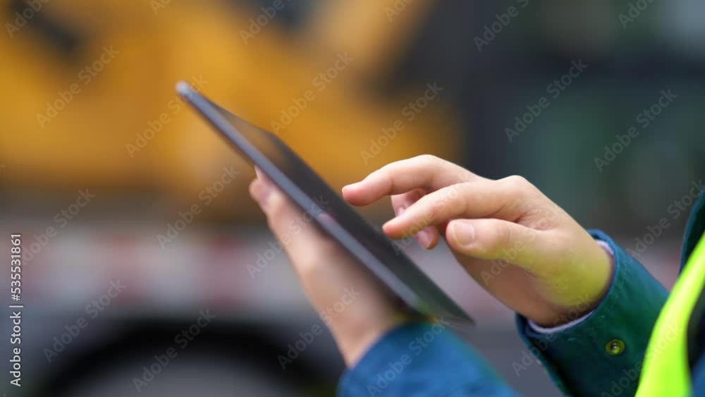 young man technician working with tablet in construction site near modern building