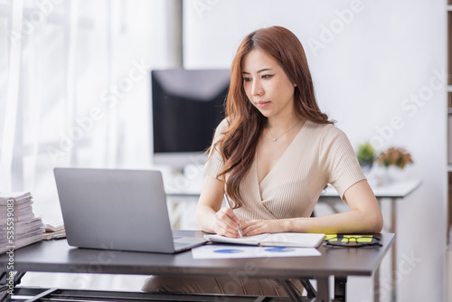 Portrait of Young Asian businesswoman is happy to work at the modern office using a laptop computer  freelance business employee online marketing e-commerce telemarketing concept.