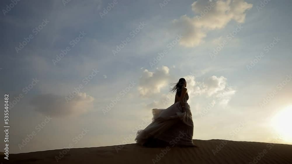A girl in a shiny dress walks barefoot on the sand A girl in a shiny dress walks barefoot on the sand