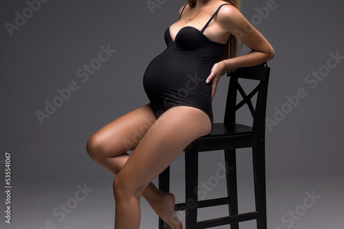 pregnant woman in black lingerie posing in studio, studio pregnancy photo shoot, pregnant belly
