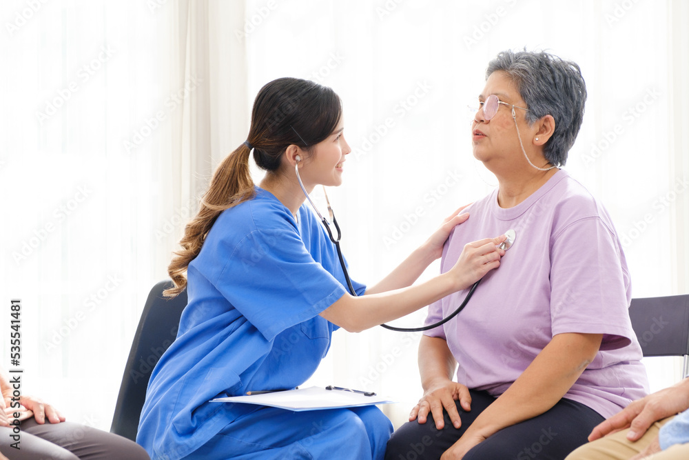 The caregiver therapist check heartbeat of Asian senior woman by stethoscope. Checking physical and mental health in a group elderly therapy session. The nursing home facilitates a support group The caregiver therapist check heartbeat of Asian senior woman by stethoscope. Checking physical and mental health in a group elderly therapy session. The nursing home facilitates a support group