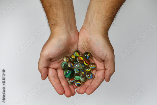 Colorful game marbles in the hands