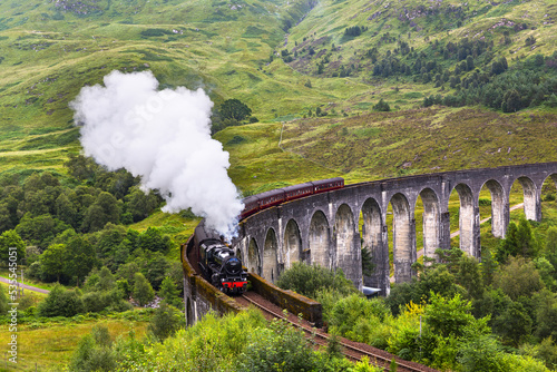 Glenfinnan railway viaduct in Scotland with the Jacobite steam train passing by