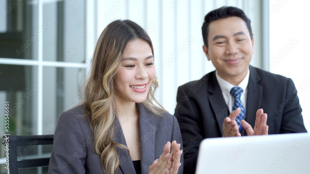 Asian businessman and businesswoman talking together in an office. Asian businessman and businesswoman talking together in an office.