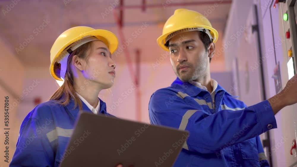 Team of electric engineer inspecting a power control panel in the central control room. Team of electric engineer inspecting a power control panel in the central control room.