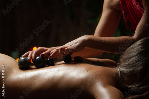 Professional massege woman client working at spa center. Young beautiful woman relaxing during full body massage at luxury resort wellness wellbeing pampering skin