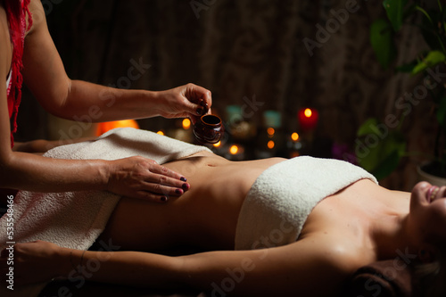 Professional massege woman client working at spa center. Young beautiful woman relaxing during full body massage at luxury resort wellness wellbeing pampering skin photo