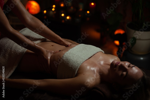 Professional massege woman client working at spa center. Young beautiful woman relaxing during full body massage at luxury resort wellness wellbeing pampering skin photo