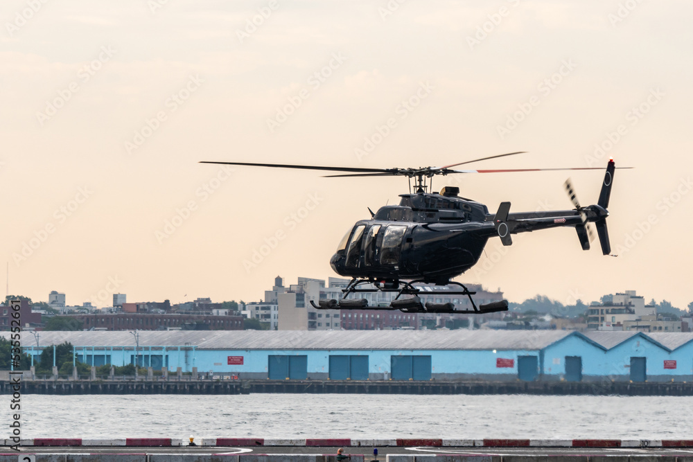 Helicopter over helipad on east river manhattan to pick up passengers for a ride Helicopter over helipad on east river manhattan to pick up passengers for a ride
