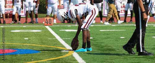 Football kicker placing the football on a tee for kickoff