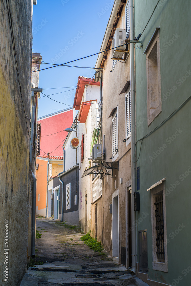 old, colorful houses and narrow streets in the center of the old town of Pula. In the background, port oddities
