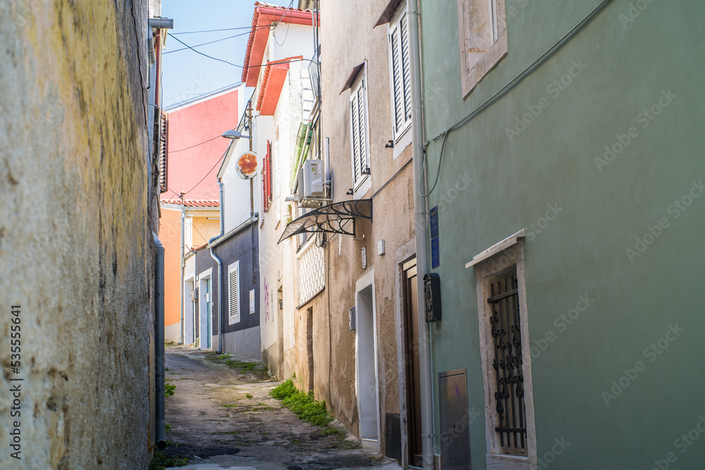old, colorful houses and narrow streets in the center of the old town of Pula. In the background, port oddities