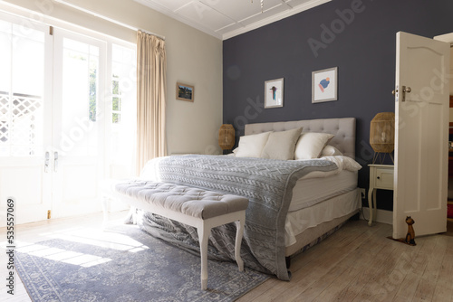 General view of bedroom interior with bed and big window