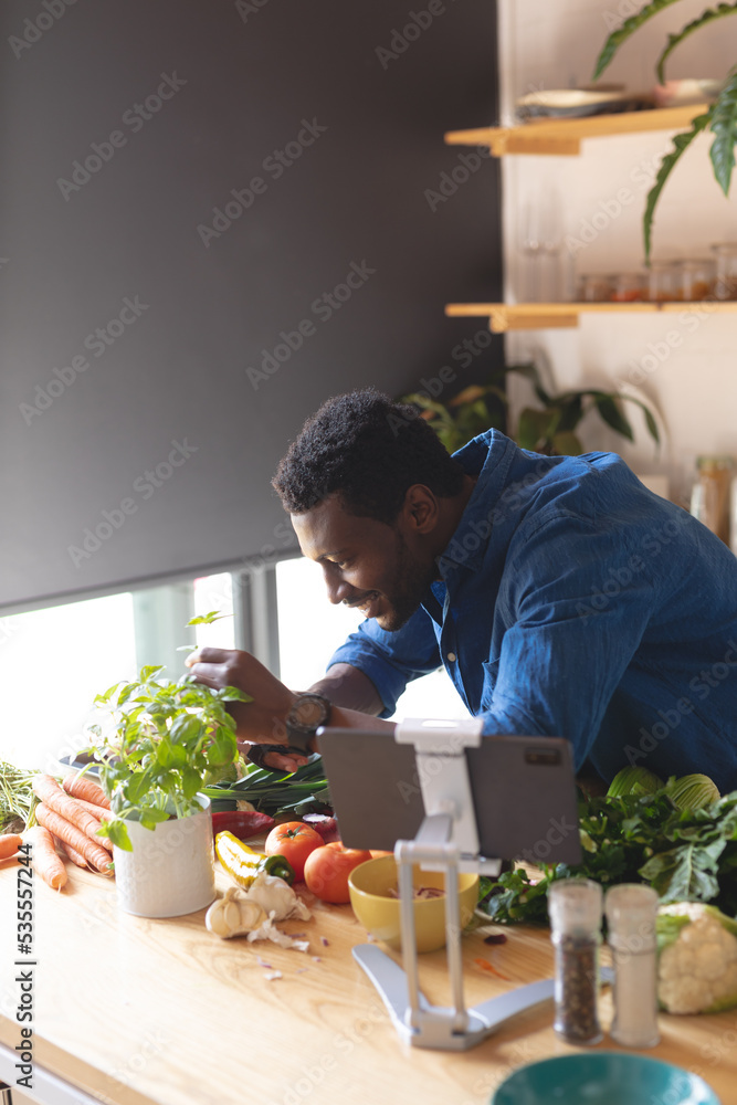 Happy african american man standing in kitchen and cooking dinner Happy african american man standing in kitchen and cooking dinner