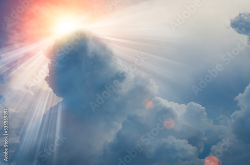 Fotografia Sun light rays or beams bursting from the clouds on a blue sky