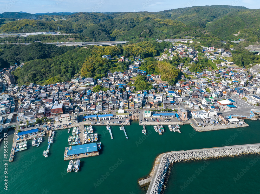 Aerial view of small coastal village and harbor on sunny day