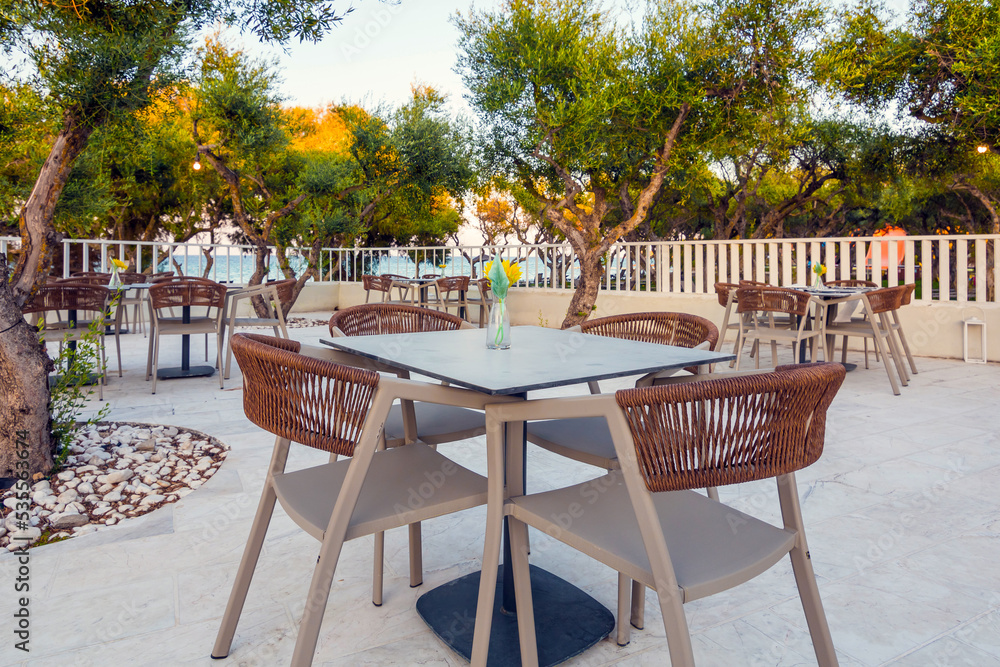Tables in restaurant on the terrace . Zakynthos, Greece. Superb summer mood, outdoor restaurant. Romantic vibes, summer colors under blue sky