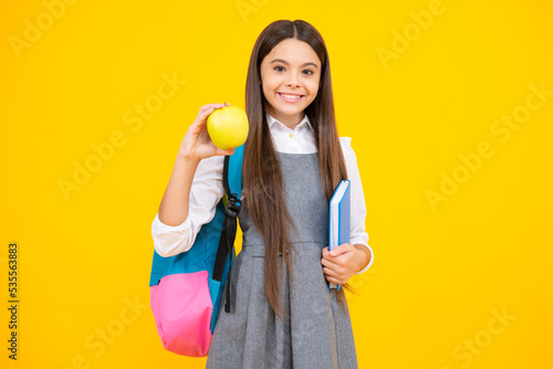 Schoolchild  teenage student girl hold book on yellow isolated studio background. School and education concept. Back to school.