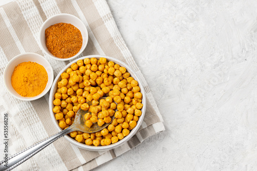 Roasting chickpeas with spices curry powder, garam masala and turmeric on napkin. Flat lay, top view with copy space