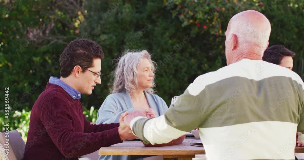 Happy caucasian family praying before dinner in garden Happy caucasian family praying before dinner in garden