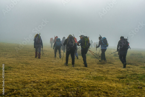 Avila, Spain 23 November 2021. several hikers climbing the mountain in fog.