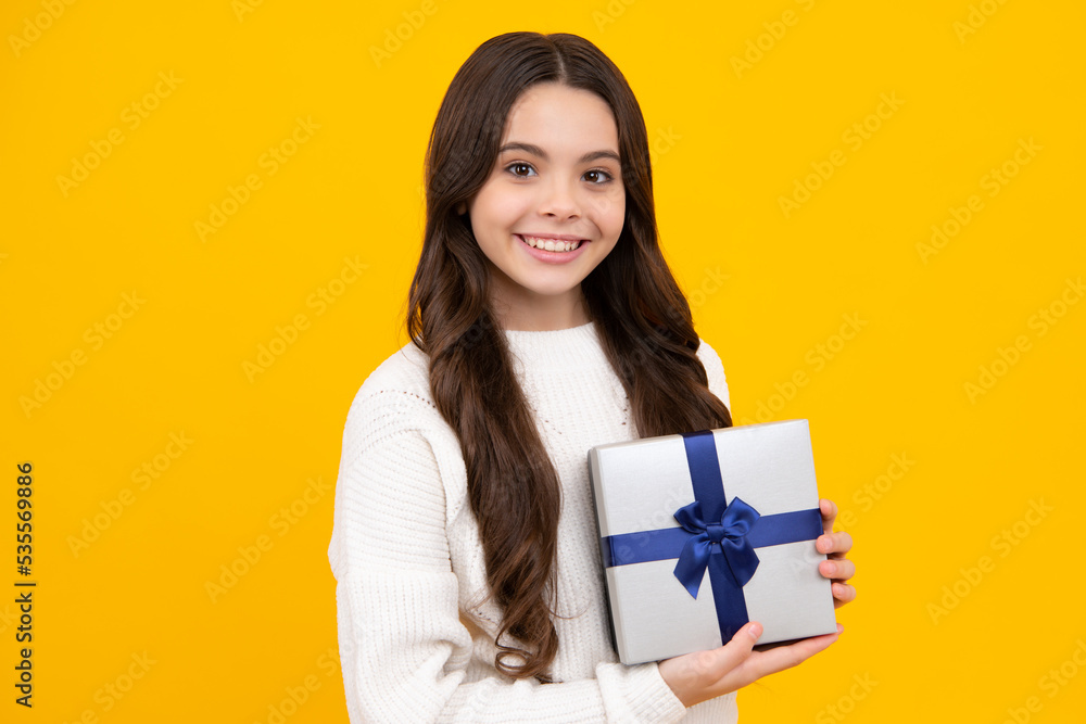 Teenager kid with present box. Teen girl giving birthday gift. Present, greeting and gifting concept. Happy face, positive and smiling emotions of teenager child. Teenager kid with present box. Teen girl giving birthday gift. Present, greeting and gifting concept. Happy face, positive and smiling emotions of teenager child.