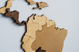Close-up of South American countries on a wooden world map on a light wall.