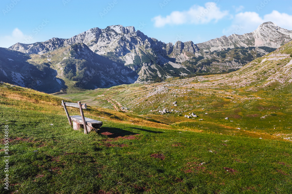 Empty wooden bench with panoramic view, Durmitor National park, Dinaric Alps, Montenegro. Selective focus