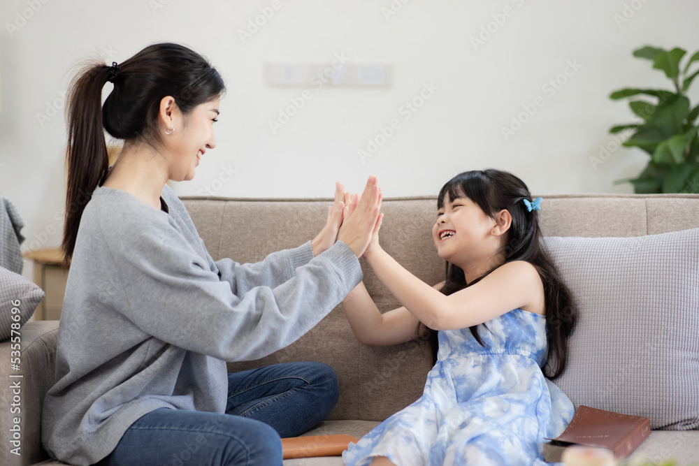 Happy asian mum and adorable preschool girl kid cuddling, Having fun together at home and Family holiday and togetherness.