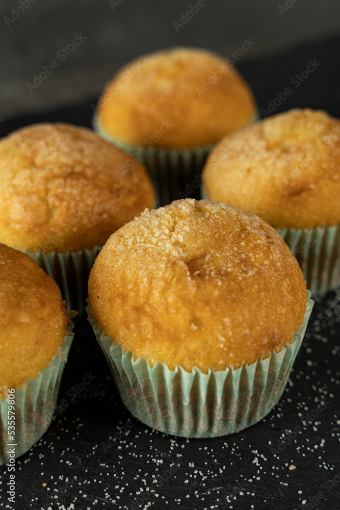 Set of delicious freshly baked cupcakes with sugar on top on a background Set of delicious freshly baked cupcakes with sugar on top on a background