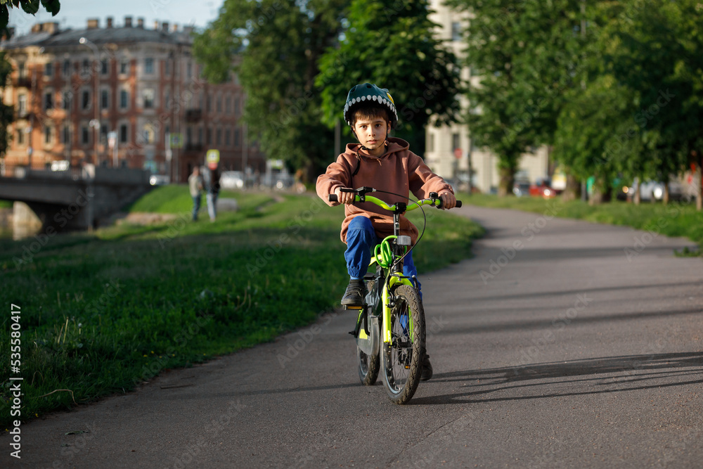 Boy learning to ride bike. Child travels through urban alley Boy learning to ride bike. Child travels through urban alley