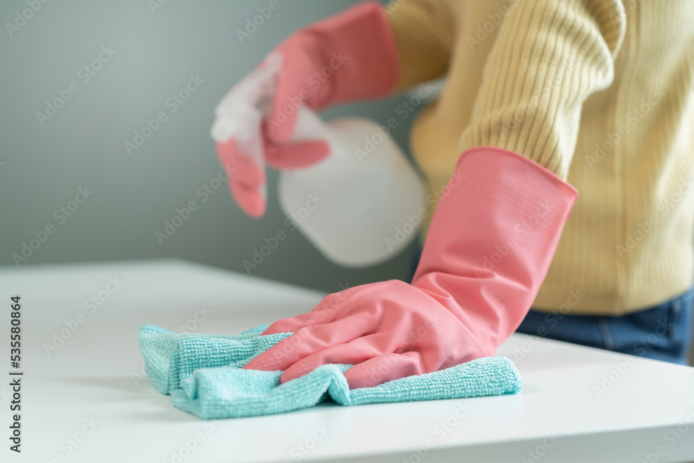 Cleanliness, asian young woman working chore clean up on white table, hand wearing gloves using rag rub remove dust with spray bottle. Household hygiene clean up, cleaner, equipment tool for cleaning.