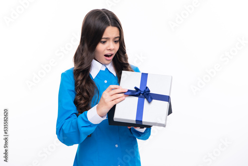 Teenager child with gift box. Present for holidays. Happy birthday, Valentines day, New Year or Christmas. Kid hold present box. Surprised emotions of young girl. © Olena