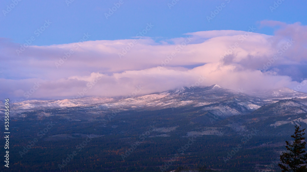 Fototapeta premium Landscape with the mountains in the clouds at sunrise.