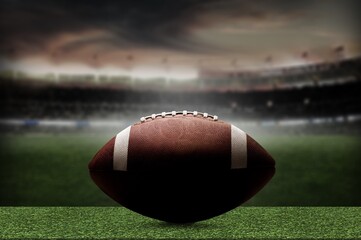 American Football ball on green field at the stadium