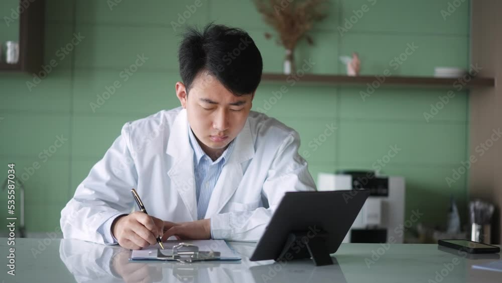 young man doctor works with tablet in office young man doctor works with tablet in office