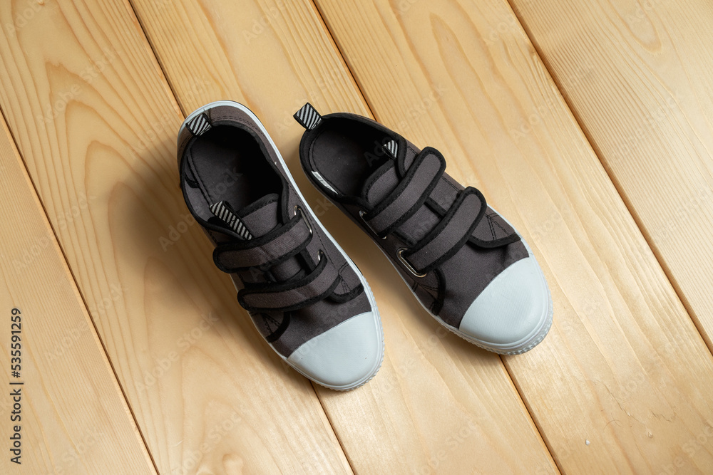 a pair of sneakers on a wooden background. a pair of sneakers on a wooden background.