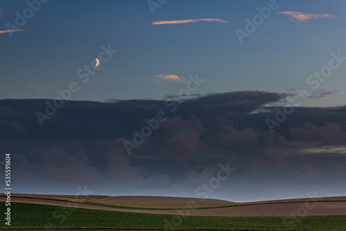 Landscape with the moon rising and clouds in the sky photo