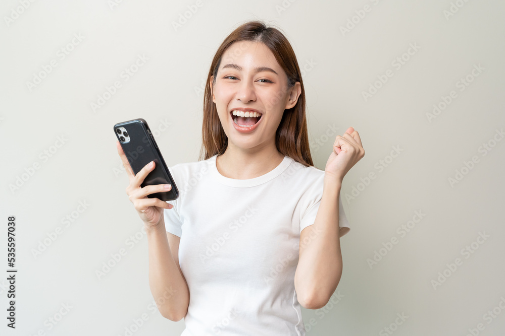 Happy Asian woman holding a smartphone and winning the prize. Happy Asian woman holding a smartphone and winning the prize.