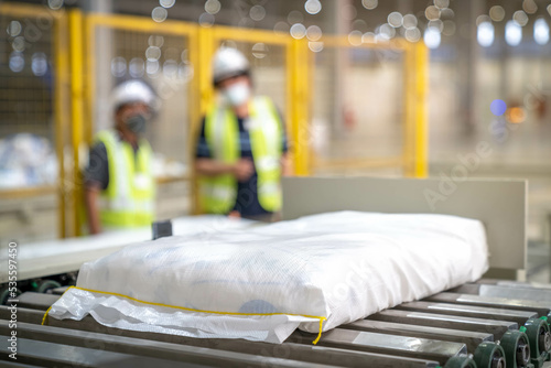 Packed sugar sacks are conveyed along industrial conveyor belts.