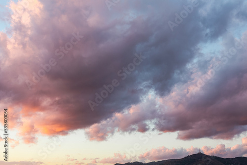 Sunset with dark clouds over the mountain silouette