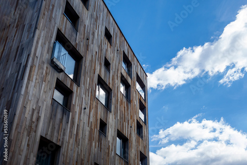 modern ooden building with sky reflecting in windows