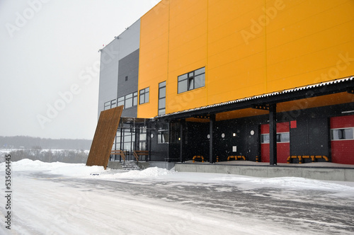The empty loading bay of a large warehouse is covered with snow in winter.