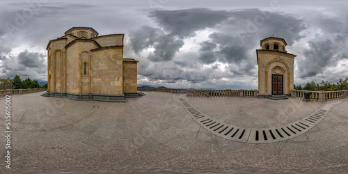 360 hdri panorama near yellow brick orthodox georgian church high in mountains in cloudy day in equirectangular spherical projection. VR AR content