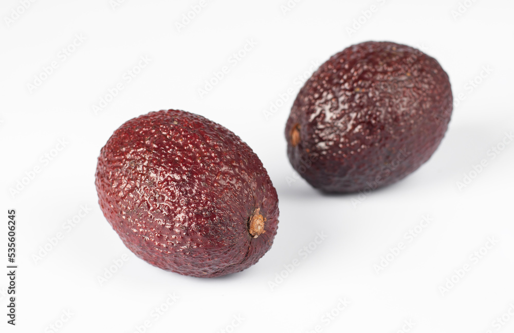Two red avocados on a white background, Horizontal image Two red avocados on a white background, Horizontal image