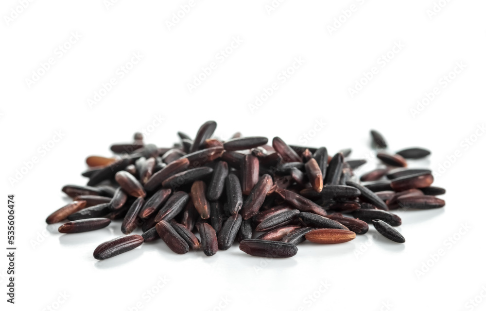 A bunch of unpolished black rice grains isolated on white background. Selective focus. . A bunch of unpolished black rice grains isolated on white background. Selective focus. .
