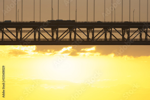 Bridge - Ponte 25 de Abril Lisbon Portugal - 25 april Bridge, cars and tracks moving over the bridge at sunrise photo