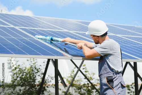 young worker cleaning solar panels.