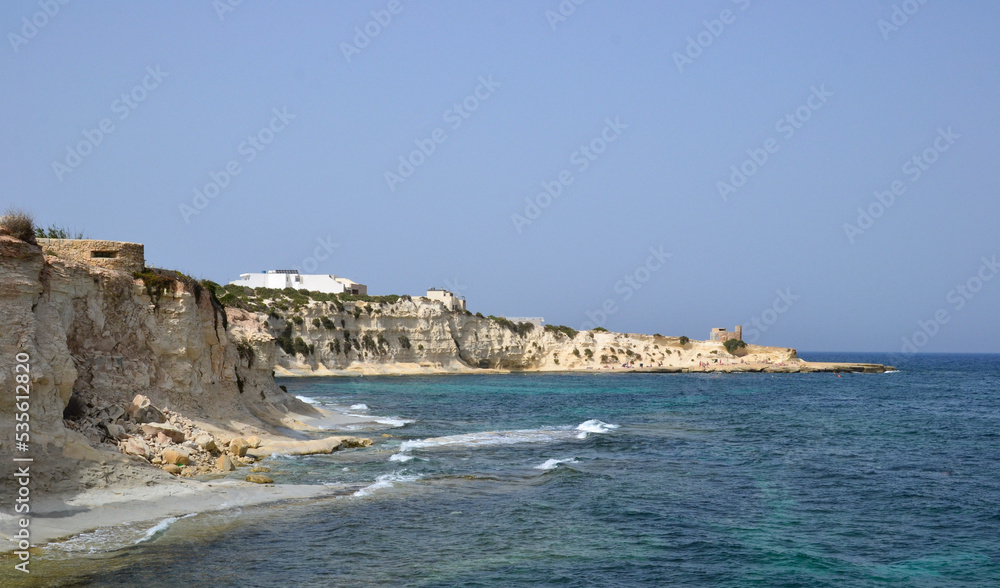 coastline with yellow cliffs and small waves of the mediterranean sea